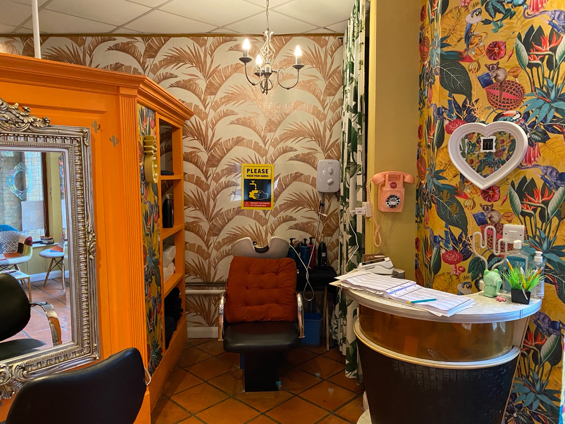 Hair Brighton reception area with bright patterned wallpaper and vintage details